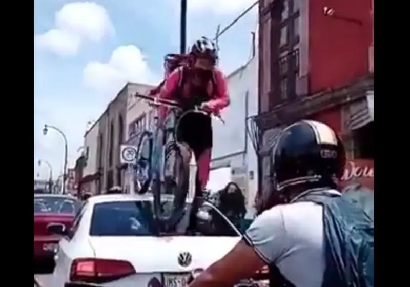 La ciclista saltó sobre el vidrio trasero del vehículo (Especial)