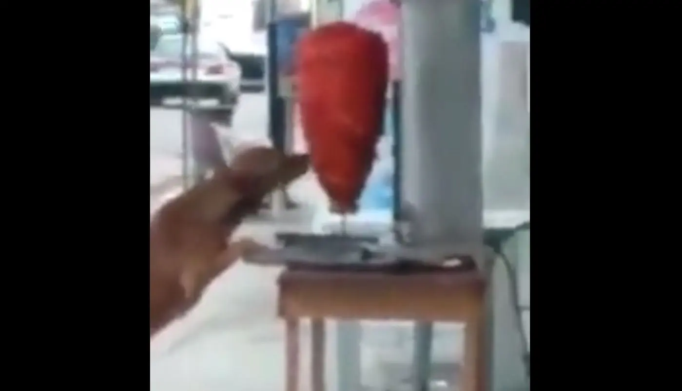 Captan a perrito dándole una mordida a trompo de tacos al pastor. Foto: captura de pantalla.