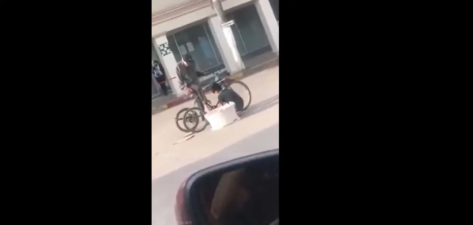 Niño ayuda a abuelito repartidor de pan a reparar su bicicleta. Foto: captura de pantalla.