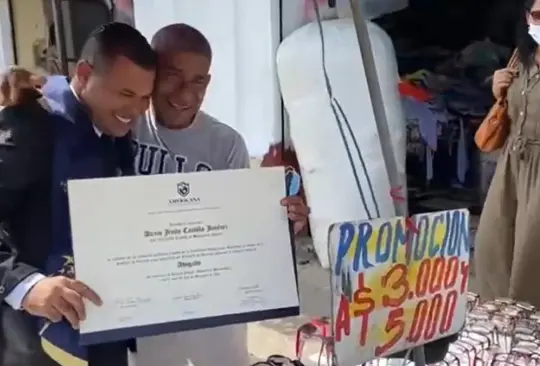 Este título es de él, recién graduado celebra con su papá en puesto ambulante