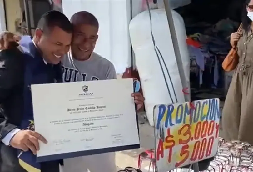 Este título es de él, recién graduado celebra con su papá en puesto ambulante Este título es de él, recién graduado celebra con su papá en puesto ambulante