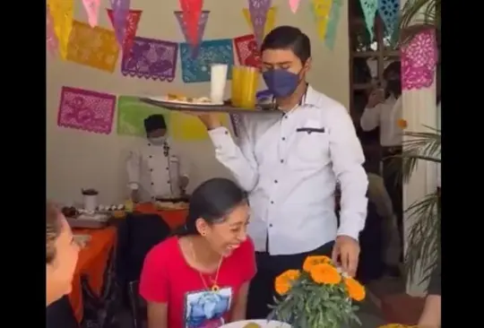 Mesero echa comida en sobre joven en restaurante. 