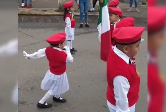 La niña bailó durante los honores a la bandera. 