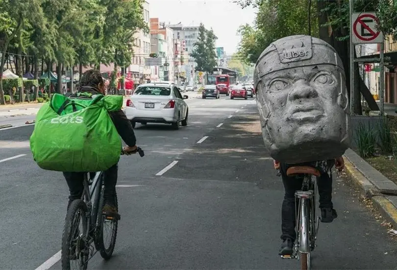 Artista entrega pedidos con mochila de cabeza olmeca Artista entrega pedidos con mochila de cabeza olmeca