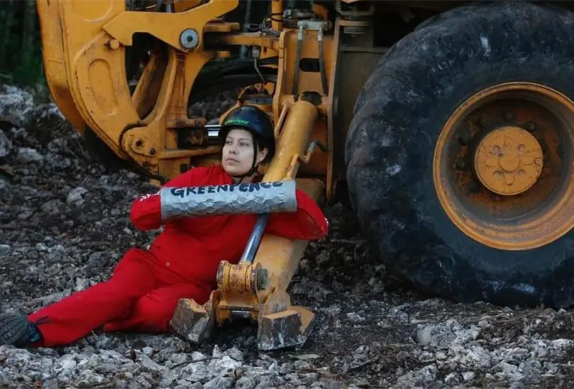 Una activista de Greenpeace se sujeta a uno de las m&aacute;quinas que trabaja en la obra del Tren Maya.