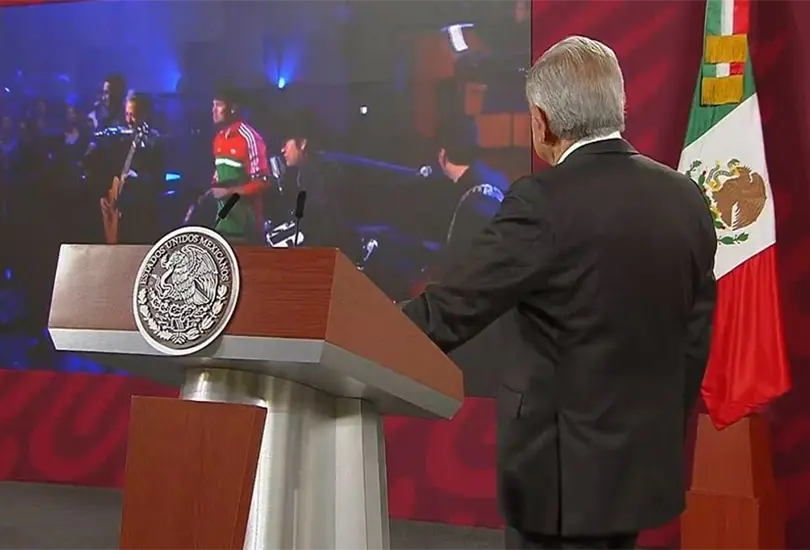 AMLO durante la conferencia de prensa ma&ntilde;anera mientras ve el video de Am&eacute;rica de los Tigres del Norte. 