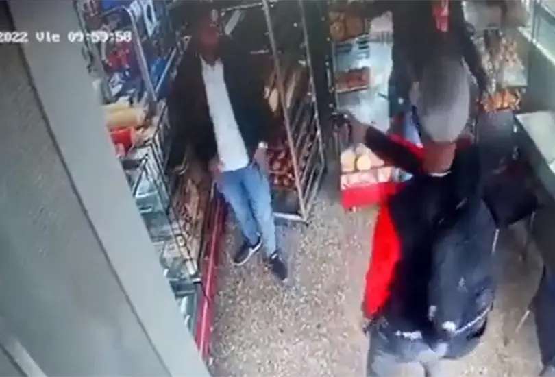 El asaltante apunta al cliente, sin saber que es un polic&iacute;a.