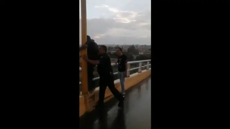 Policías rescatan a hombre que intentaba lanzarse de puente - Tomada de video