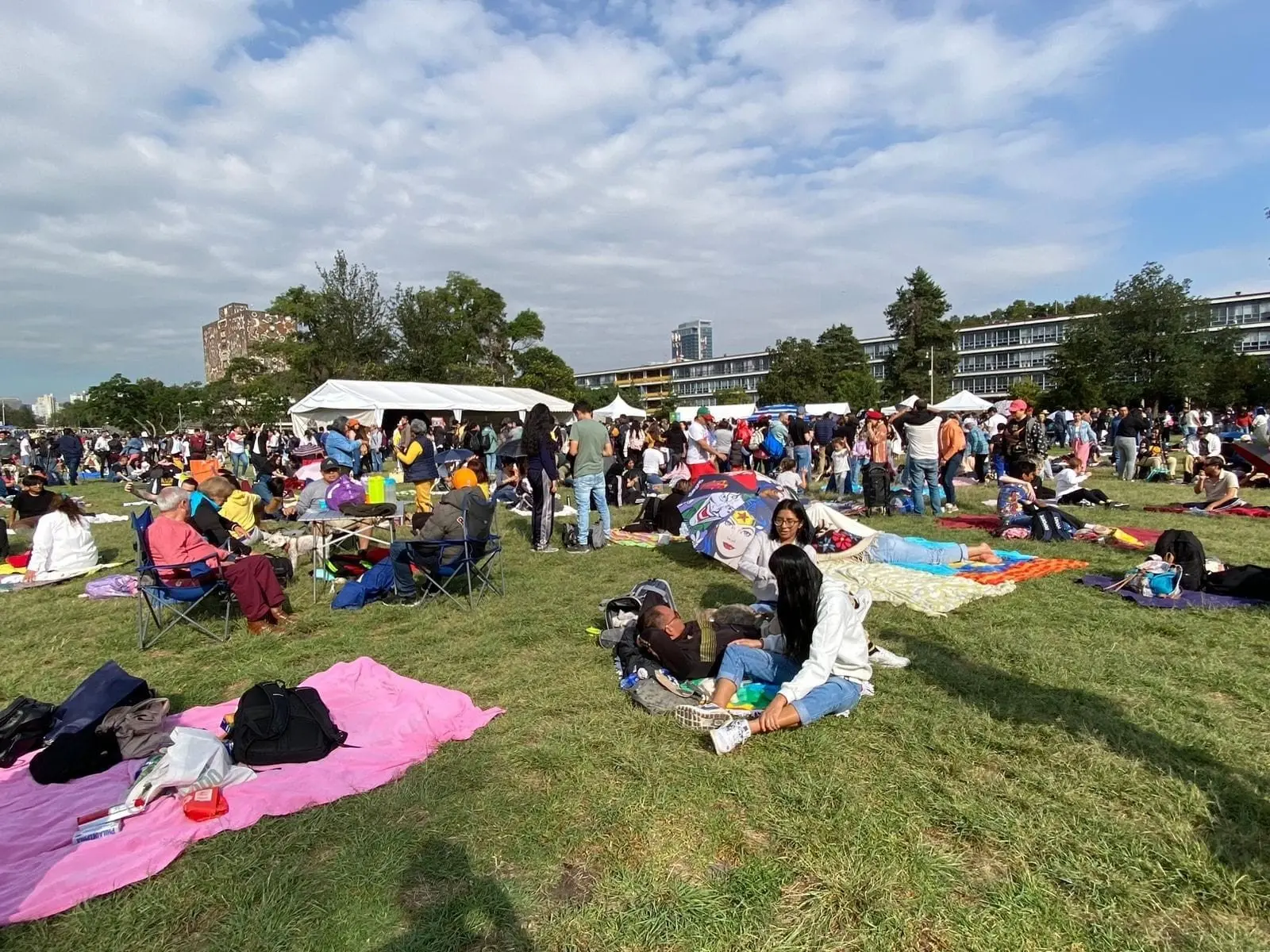 Familias mexicanas reunidas en las Islas de Ciudad Universitaria contemplan el evento astronómico. 