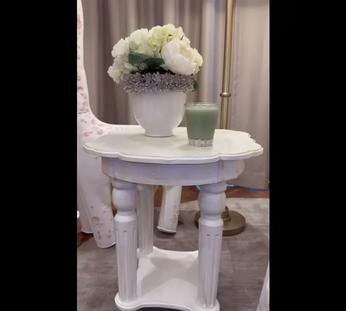 La mesa de noche que está junto al sofá es un diseño clásico en blanco de la marca Alfamarquesa, la cual tiene un costo de 5,750 pesos.