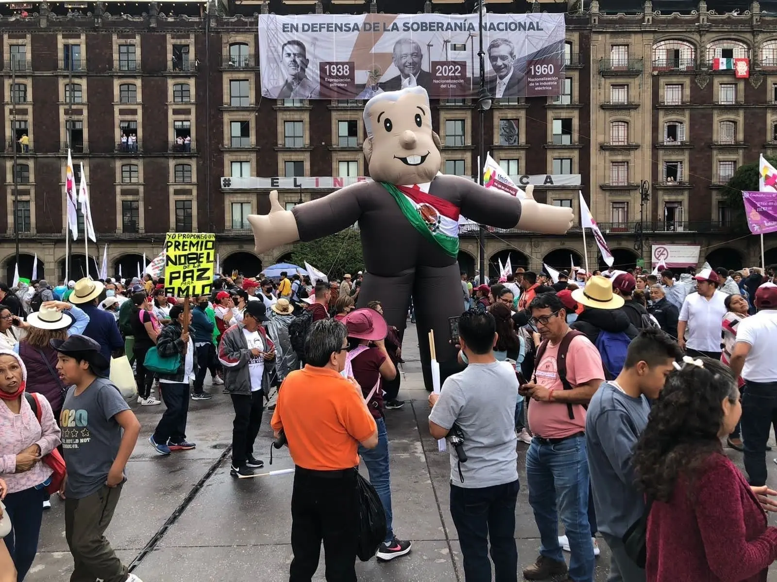 Magno globo del presidente López Obrador llevado por algunos asistentes al evento. 