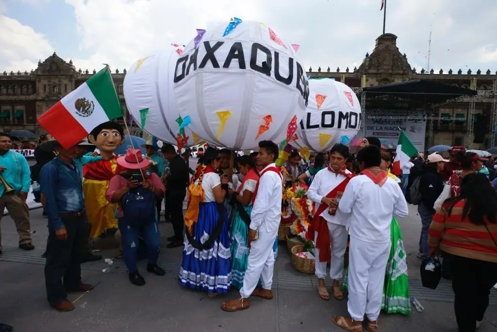 A pesar del clima y de la ligera presencia de lluvia, las personas siguen llegando al Zócalo para conmemorar el 85 aniversario de la Expropiación Petrolera. 