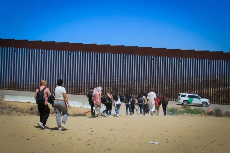 Migrantes en el muro fronterizo. Créditos: Cuartoscuro