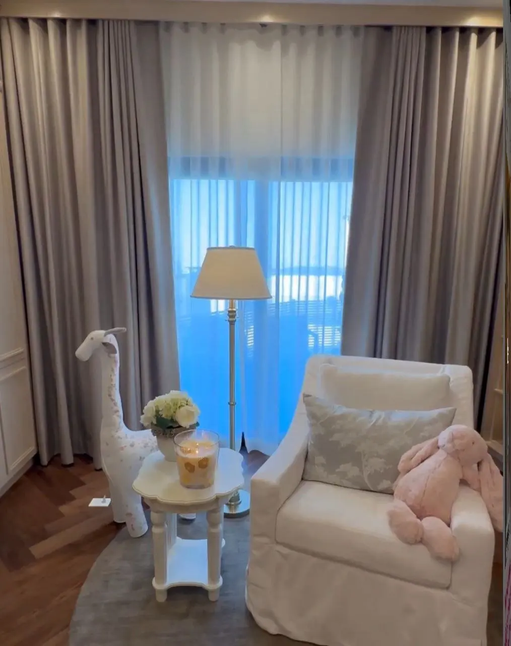 En el centro de la habitación hay una jirafa y un elefante de peluche.