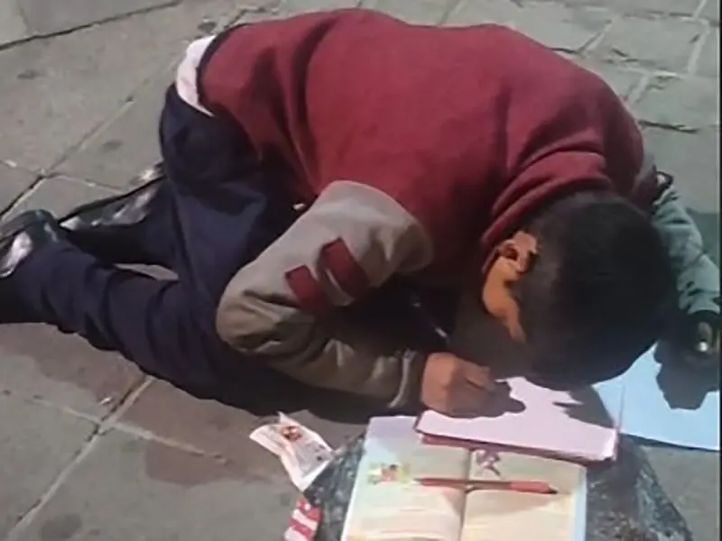 Este ni&ntilde;o vende dulces en la calle y hace su tarea en sus ratos libres. 