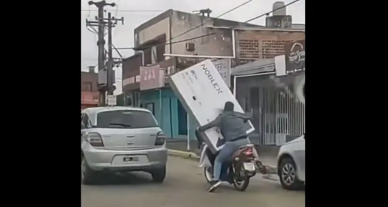 El hombre trasladaba la pantalla en una moto. Foto: captura de pantalla.