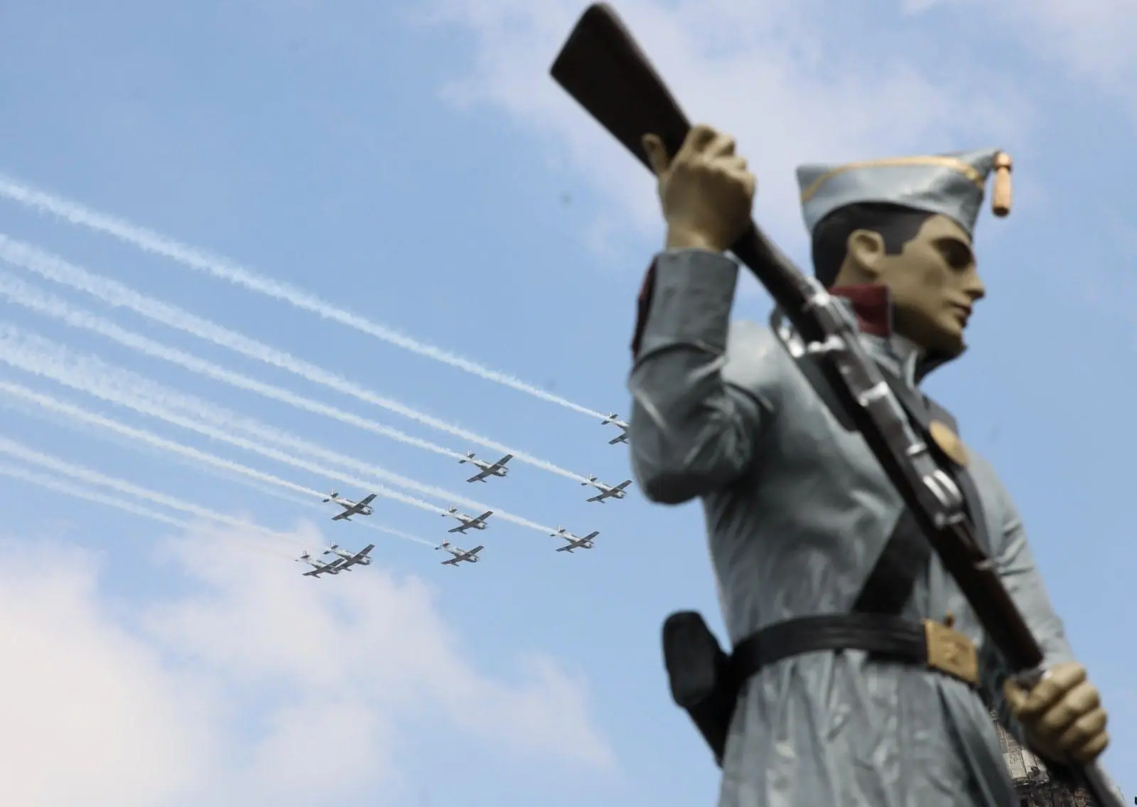 Personal de la Fuerza Aérea mexicana ejecutó un rompimiento ascendente, con nueve aeronaves T-6C+, coloreando el cielo con humo tricolor para dar inicio al desfile militar.