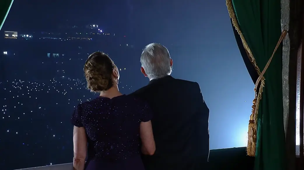 El presidente abraza a su esposa mientras disfrutan del espectáculo de fuegos artificiales.<br>