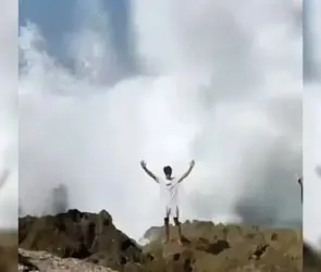 El momento exacto en que una ola gigante se traga a un joven que posaba para una foto 
