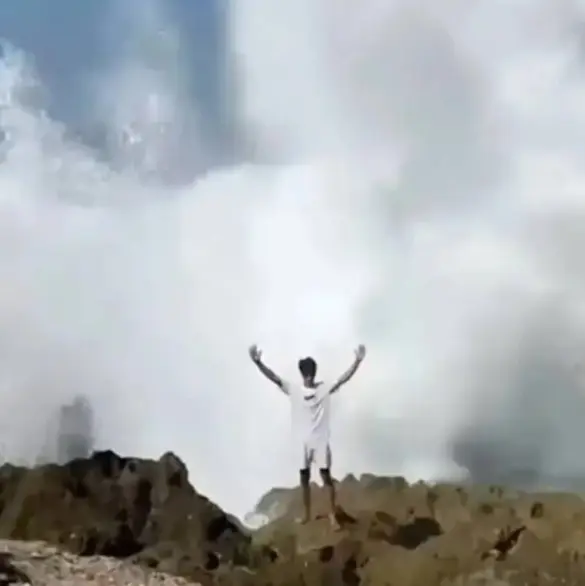 El momento exacto en que una ola gigante se traga a un joven que posaba para una foto 