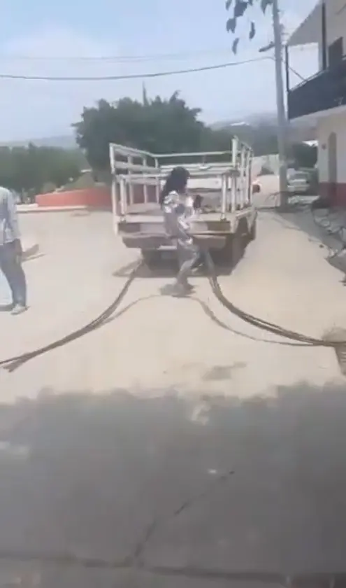 En el video se observa cómo la mujer jala las mangueras tras cortarlas. Captura de pantalla.
