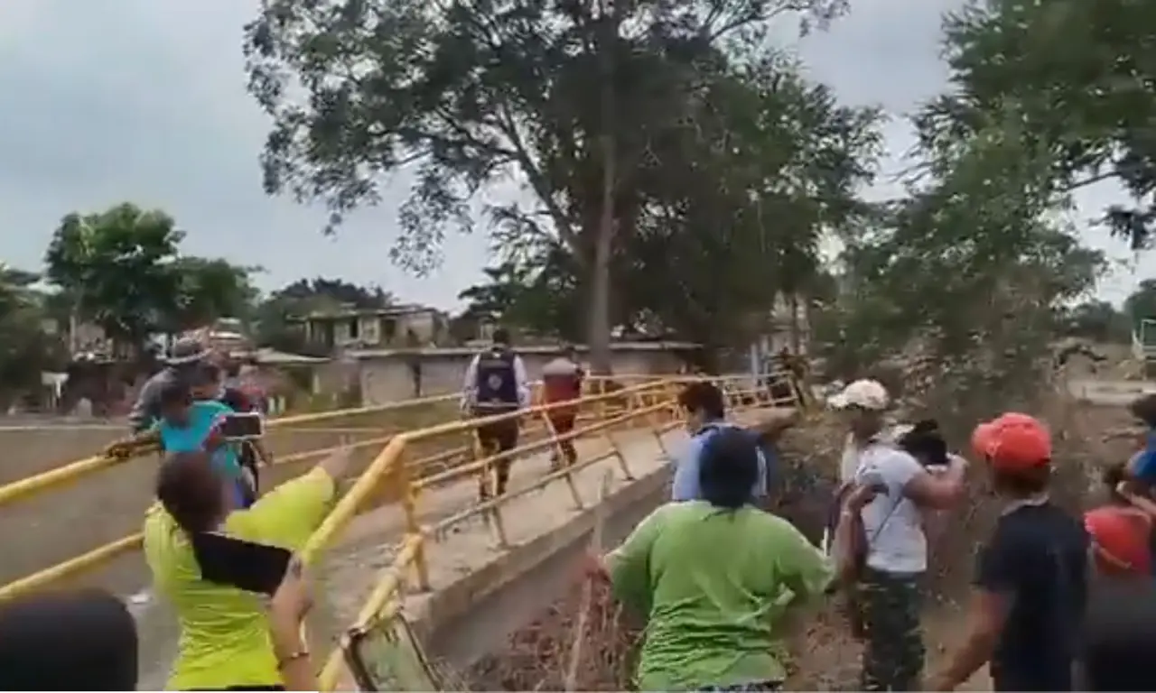  Los pobladores comenzaron a lanzarle puñados de lodo, obligándola a retirarse caminando por un puente peatonal mientras los reclamos continuaban. 