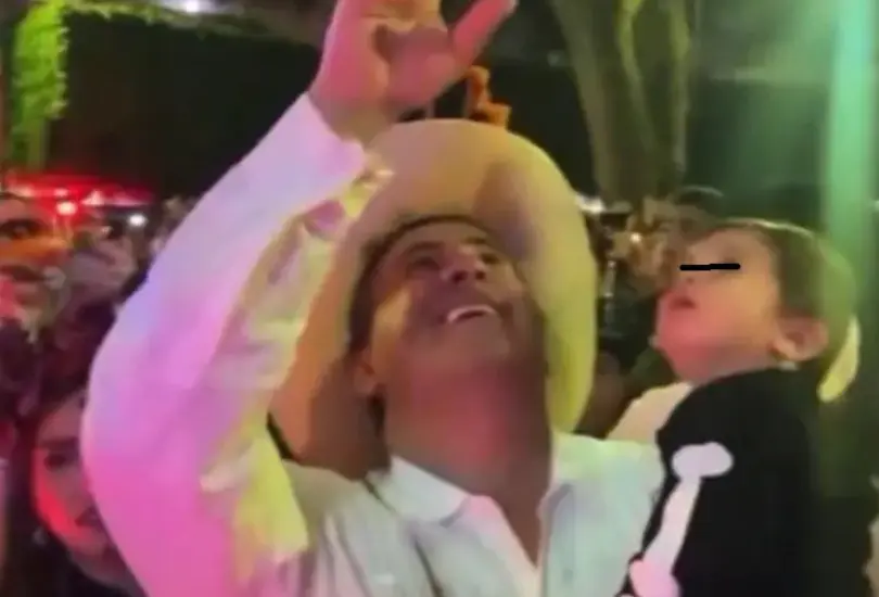 El edil cargaba a su pequeño hijo mientras saludaba a las personas durante el festejo de Día de Muertos.