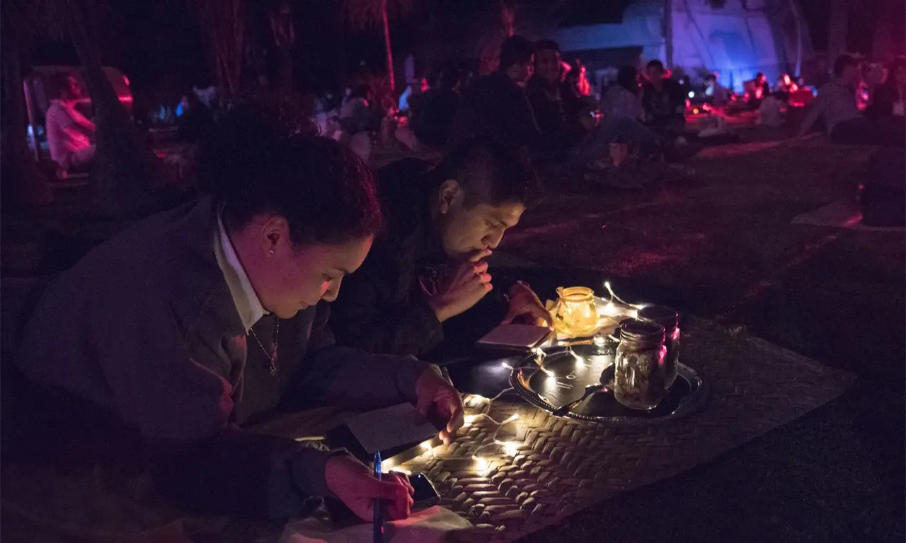  La iluminación, las linternas y el entorno natural crean una postal viva donde cada asistente forma parte del paisaje. 