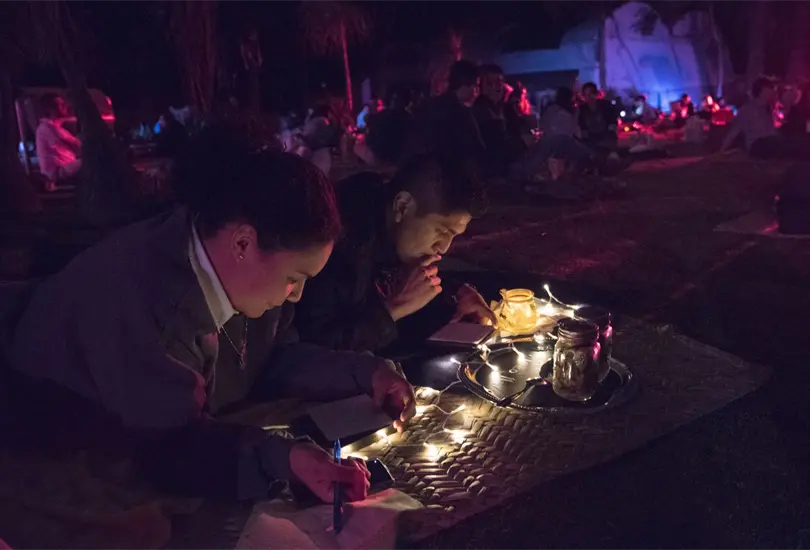 La iluminación, las linternas y el entorno natural crean una postal viva donde cada asistente forma parte del paisaje.