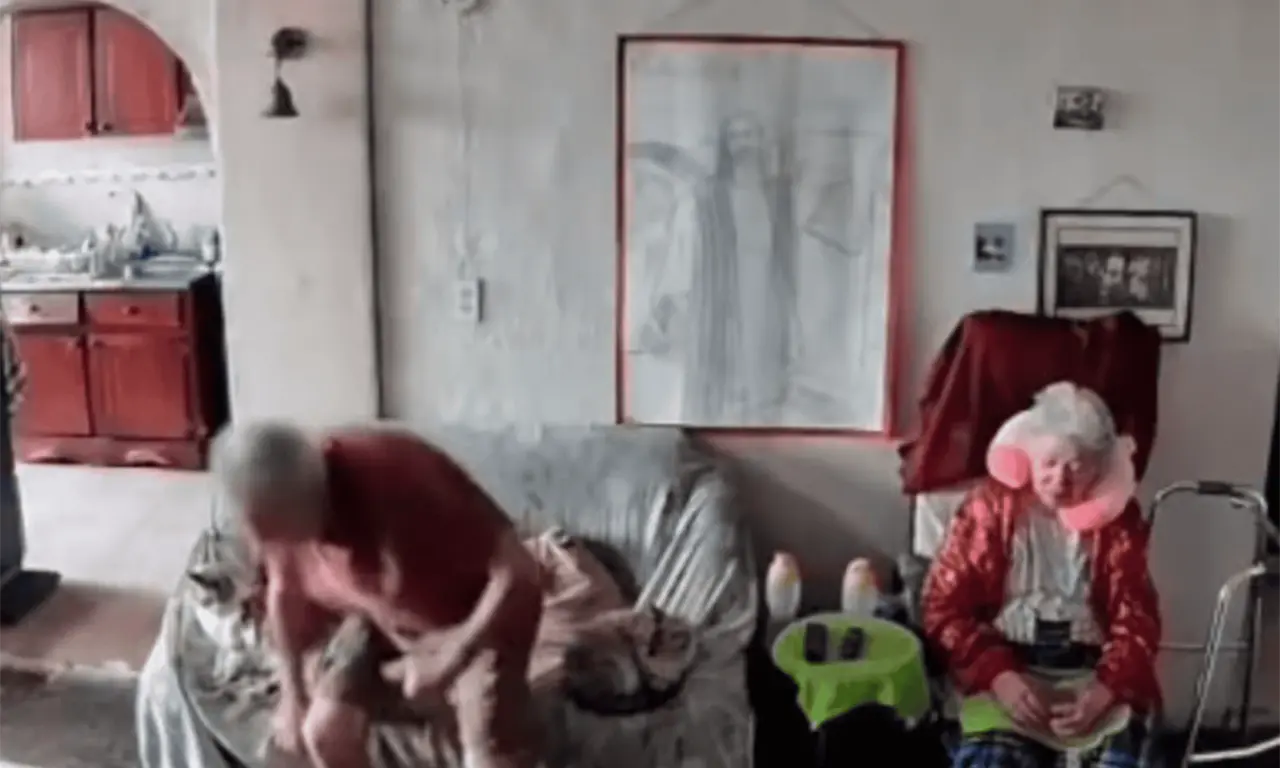  Mientras el interior de la casa se convierte en una escena de caos, la pareja se aferra mutuamente tratando de mantenerse en pie. 